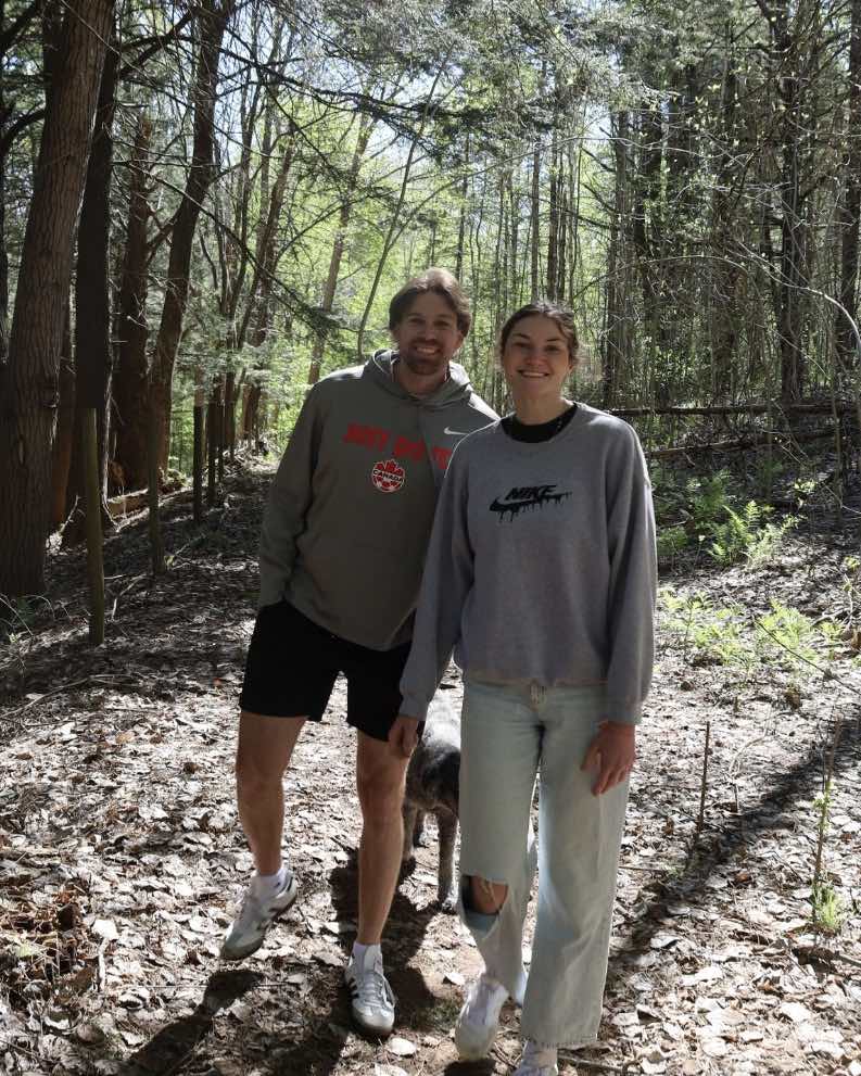 Chris Gallant and his girlfriend Millie walking together in a wooded area